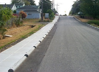 At-grade concrete sidewalk separated by curb stops. (City of Seattle)