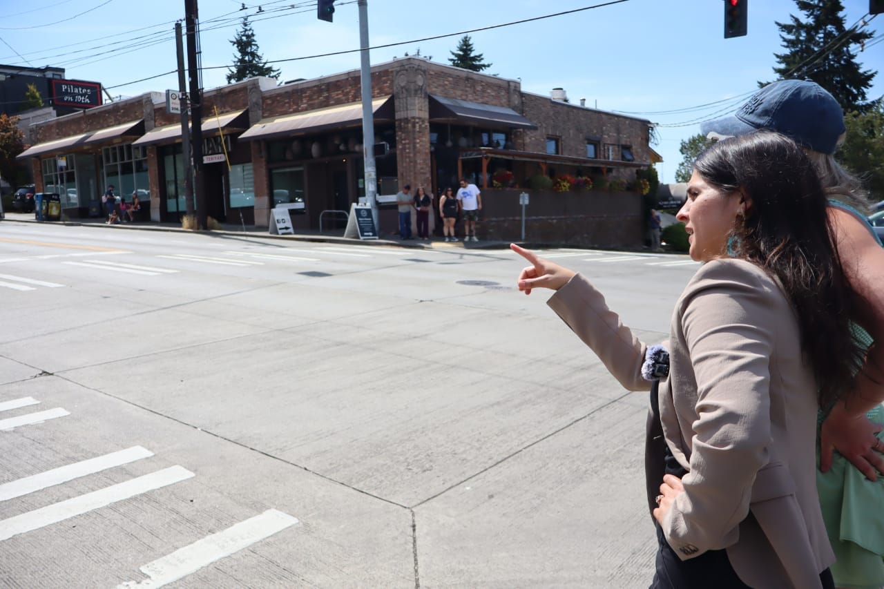 Rinck points across an intersection toward a corner store.