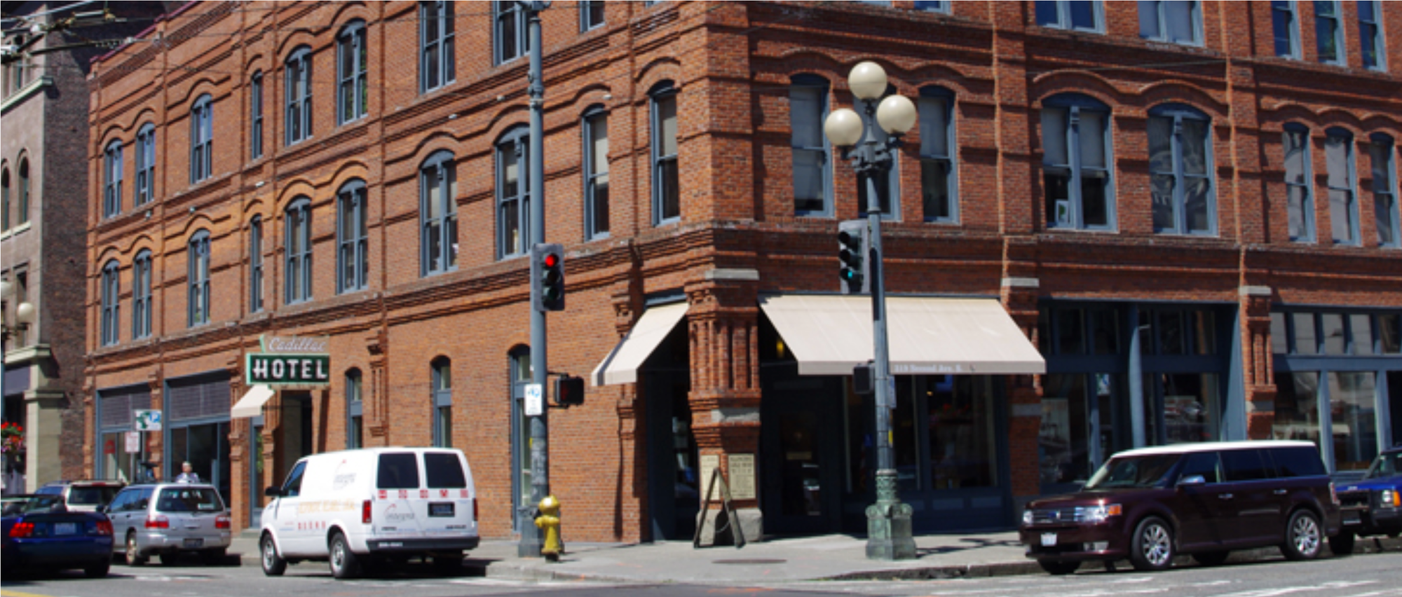 Street scene featuring the historic brick facade of the Cadillac Hotel on Jackson Street in Seattle's Pioneer Square.