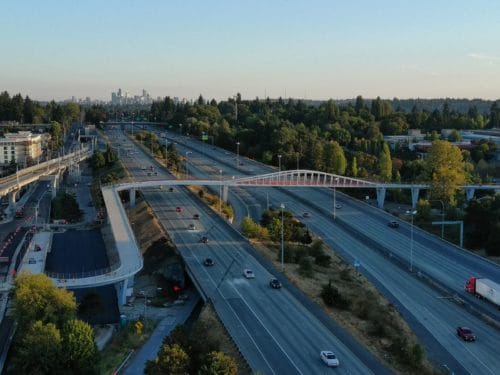 A photo of the Northgate Pedestrian and Bicycle Bridge from above and toward the downtown skyline.