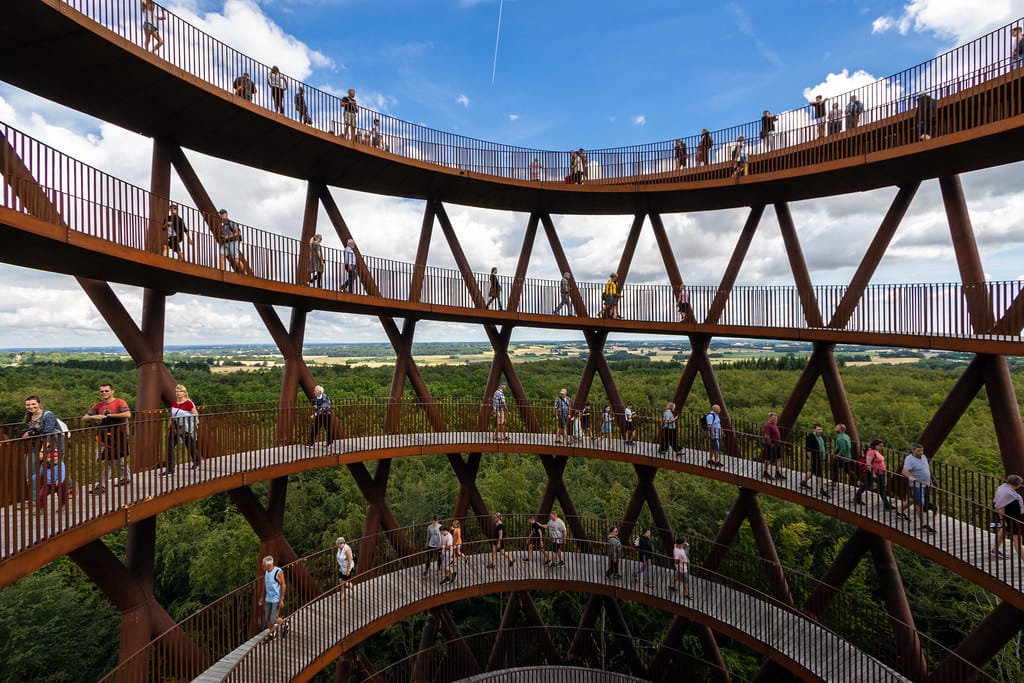A photo of floors of an open air spiral shaped tower looking out over trees.