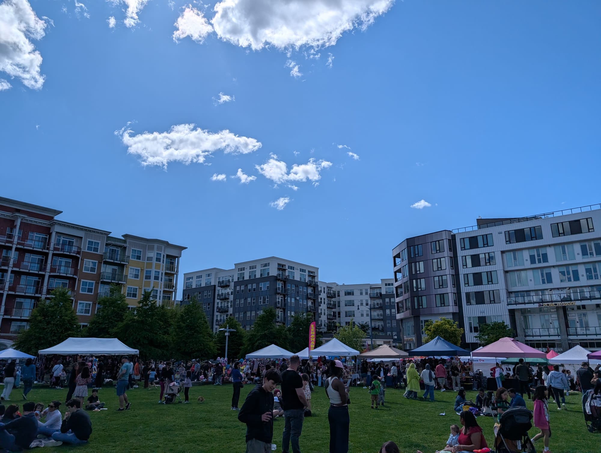 A busy park with apartments in the background