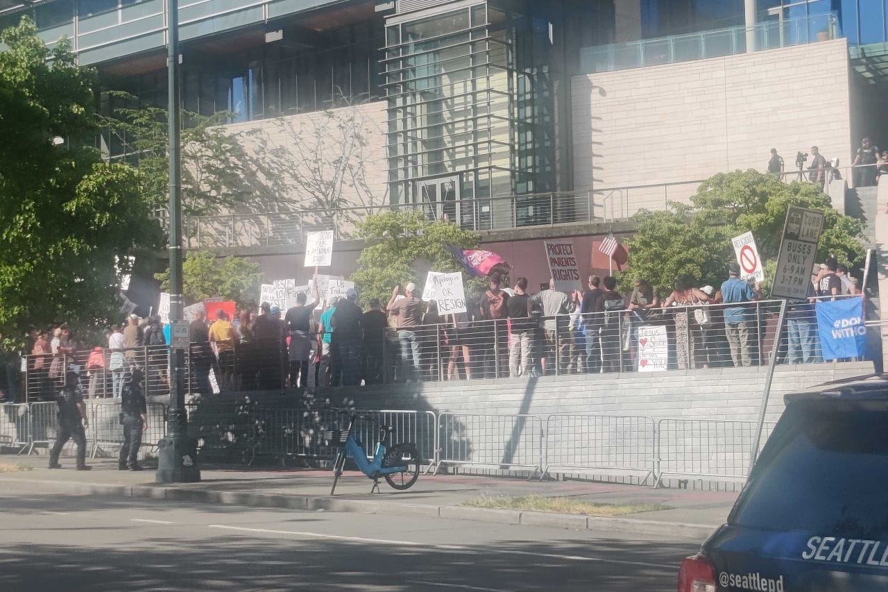 A group of about 100 protesters wave signs standing up for LGBTQ rights and a Christianity based on love rather than hate.