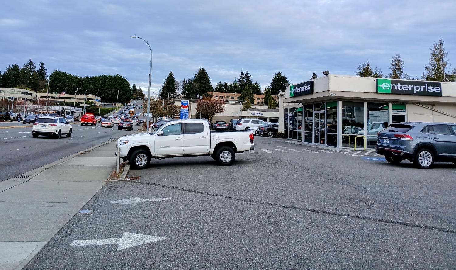 An Enterprise car lot next to a busy collector road, a very suburban environment.