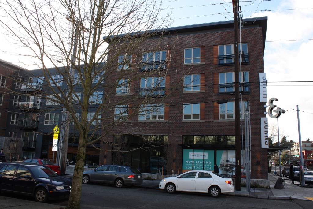 Smith & Burns forgoes the vinyl siding with which many Seattleites have grown weary for a refined brick facade. It also includes murals on the opposite side.