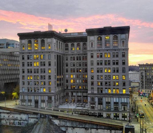 Superior Court Strikes Down Seattle’s First-in-Time Renter Law A ten story building with a pinkish purple sunset in the background