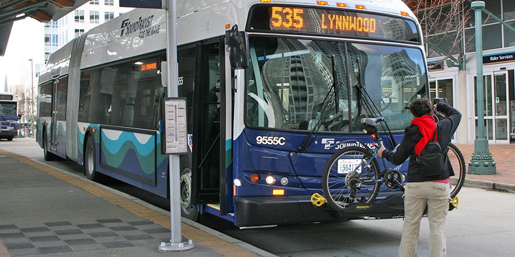 A person loading a bike on a Sound Transit bus, a Route 535 headed to Lynnwood.