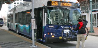 A person loading a bike on a Sound Transit bus, a Route 535 headed to Lynnwood.