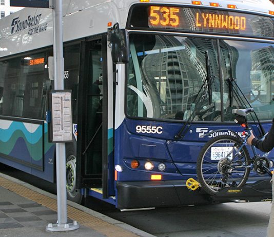 Refining I-405 BRT, Sound Transit Seeks Input on Station Access and Amenities A person loading a bike on a Sound Transit bus, a Route 535 headed to Lynnwood.