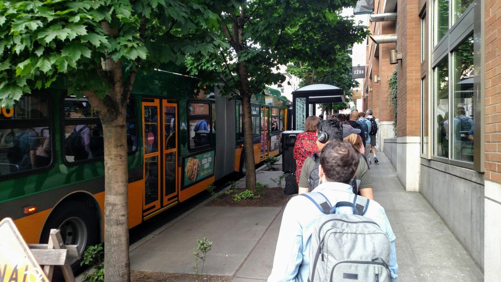 A long line of riders wait to board a Route 8 bus at Denny and Westlake. (Photo by Doug Trumm)