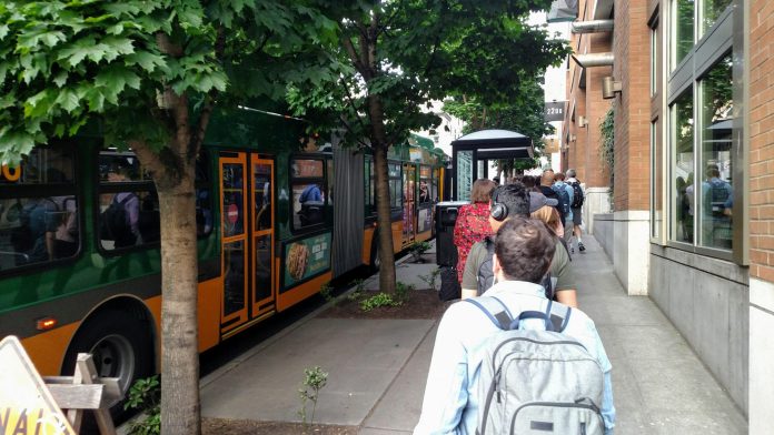 A long line of riders wait to board a Route 8 bus at Denny and Westlake. (Photo by Doug Trumm)