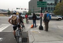 Three Lawmakers Say Their Constituents Should Get a Free Pass on Blocking Seattle Crosswalks and Transit Lanes Three people biking and two pedestrians wait for a long line of cars queuing on Mercer Street in South Lake Union.