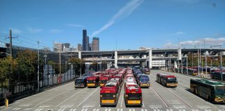 Rows of buses with the I-90 ramps and Seattle skyscrapers in the background.