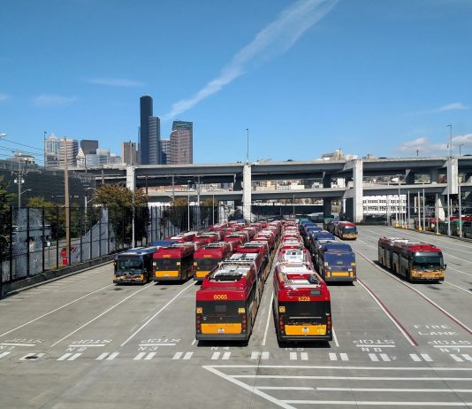 Morales Leads on Doubling Seattle Transit Benefit District Proposal, Colleagues Dither Rows of buses with the I-90 ramps and Seattle skyscrapers in the background.