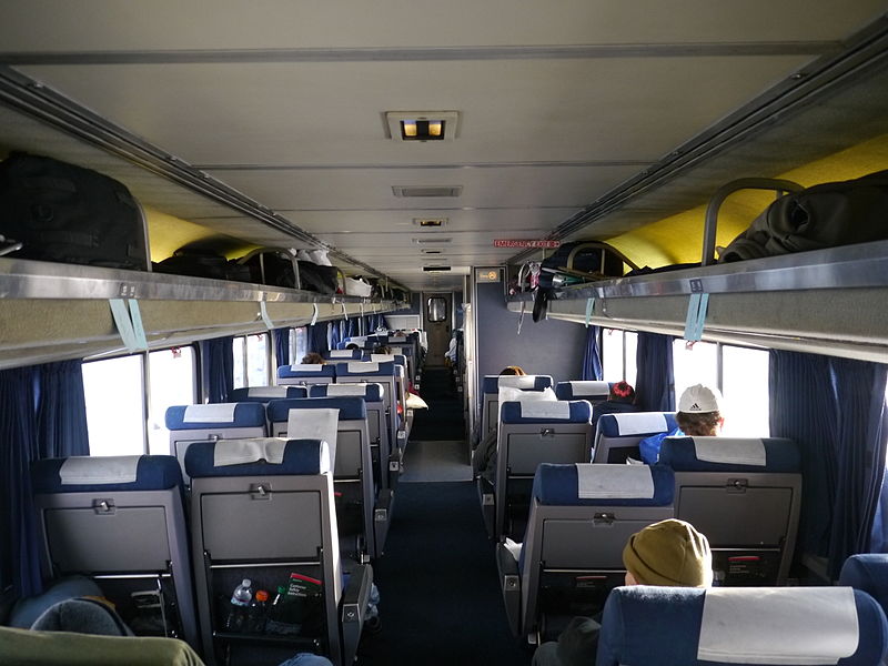Interior of the Amtrak Coast Starlight Superliner car showing seats and overhead luggage racks.