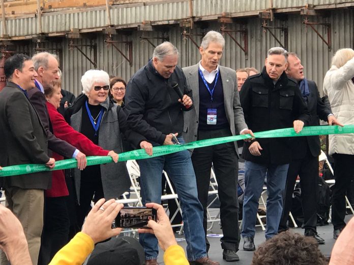Inslee holds the scissors and other high-level officials look on outside the SR-99 tunnel in February 2019.