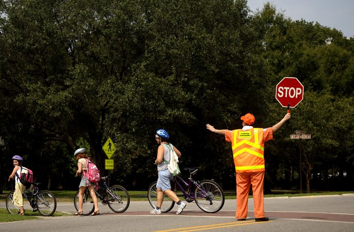 School crossing guards are a low paid, but essential position. Seattle Public Schools has struggled to recruit and train school crossing guards in recent years. (Credit: Nicholas Pilch)