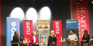 Jenny Durkan and Cary Moon sit in the middle of the forum with journalists including David Kroman and Heidi Groover on the wings.