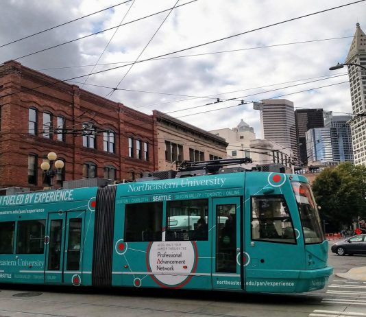 With Simple Improvements, Streetcars Can Thrive in Seattle teal streetcar in Pioneer Square with Smith Tower and other buildings