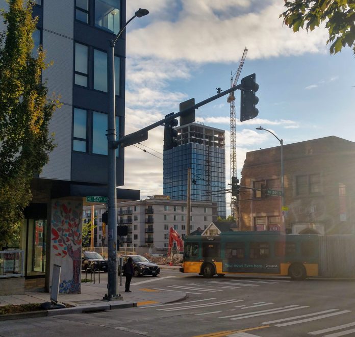 The M Tower, the first highrise out of the gates after the U District was rezoned in 2017, rises in the background of this shot of The Ave at NE 50th St. (Photo by Doug Trumm)