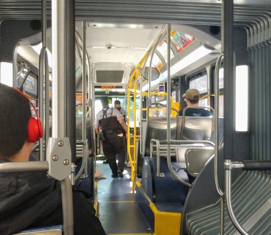 Fare Enforcement on First Day of School Reinforces Need for Reform Two fare enforcement officers work their way toward the front of a bus after checking a few riders proof of payment.