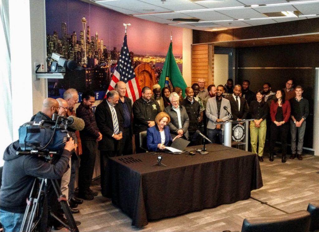 Mayor Jenny Durkan signs the Fare Share Plan into law at city hall. (Photo by author)