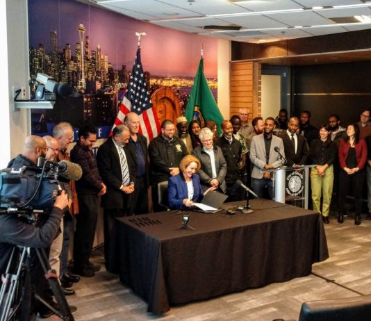 JumpStart Seattle Passes 7-2–Will Mayor Durkan Sign It or Force Veto Override? Mayor Jenny Durkan signs the Fare Share Plan into law at city hall. (Photo by Doug Trumm)