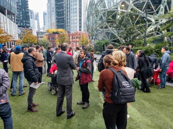 An Amazon contract employee who opposed Amazon's copious campaign spending talks to a reporter. before an October 24th rally at the Amazon Spheres. (Photo by author)