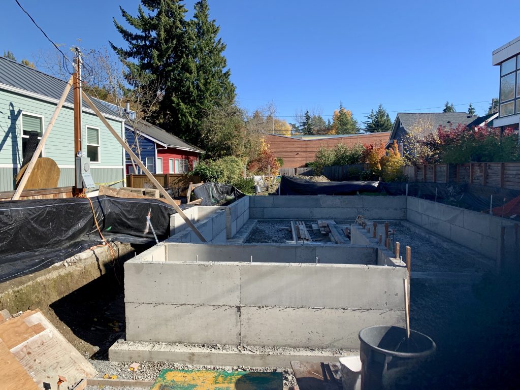 Next to the Cunningham's backyard cottage is a new building under construction with a traditional excavated cement foundation. By using a raised foundation, MyKabin significantly reduces cost and construction time. (Photo by author)