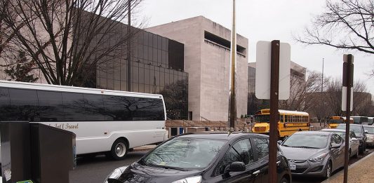An electric car charging outside a museum. (Credit: Slowking4, Wikimedia Commons)