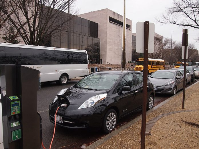 An electric car charging outside a museum. (Credit: Slowking4, Wikimedia Commons)