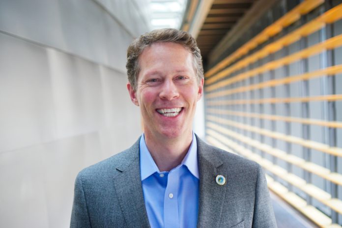 Alex Pedersen poses in a suitcoat in a City Hall hallway