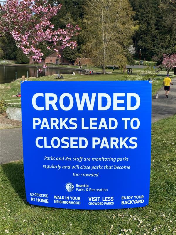 "Crowded parks lead to closed parks," reads the City's sign at Seward Park, suggesting people stay home or in their yards instead.