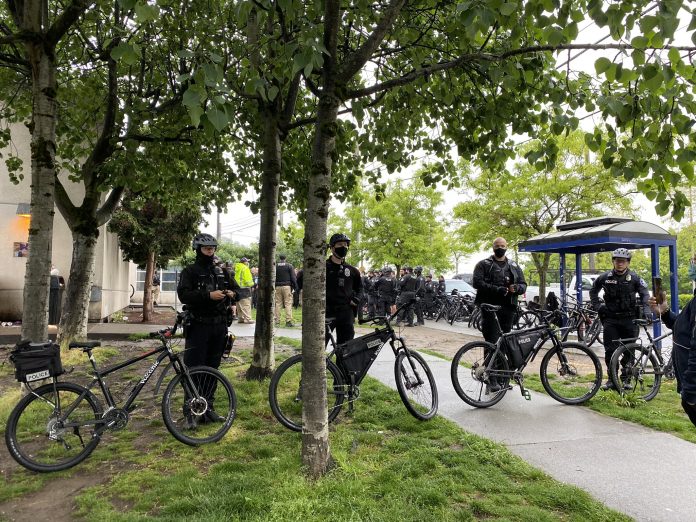 Police barricade - Photo by Enrico Doan Police gathered in large numbers to ensure houseless were swept and cleared in rapid fashion with no interruption from encampment residents or their allies. (Photo by Enrico Doan)