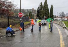 The System Is Broken for Us Already People walk and roll across the street in the rain with a car in the background."This system is broken for us already. We want change. We want a different and a re-imagined transportation system," was the caption I wrote for my presentation. (Photo by David Seater)