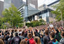 Council Set to Pass JumpStart Seattle Payroll Tax Protesters react with fists raised in solidarity as Nikkita Oliver takes the stage at City Hall on Wednesday June 3rd. (Photo by Doug Trumm)