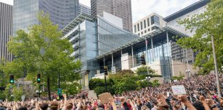 Protesters react with fists raised in solidarity as Nikkita Oliver takes the stage at City Hall on Wednesday June 3rd. (Photo by Doug Trumm)