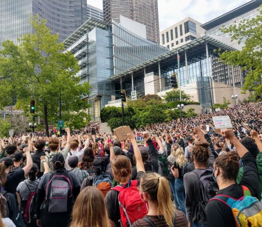 Council Set to Pass JumpStart Seattle Payroll Tax Protesters react with fists raised in solidarity as Nikkita Oliver takes the stage at City Hall on Wednesday June 3rd. (Photo by Doug Trumm)