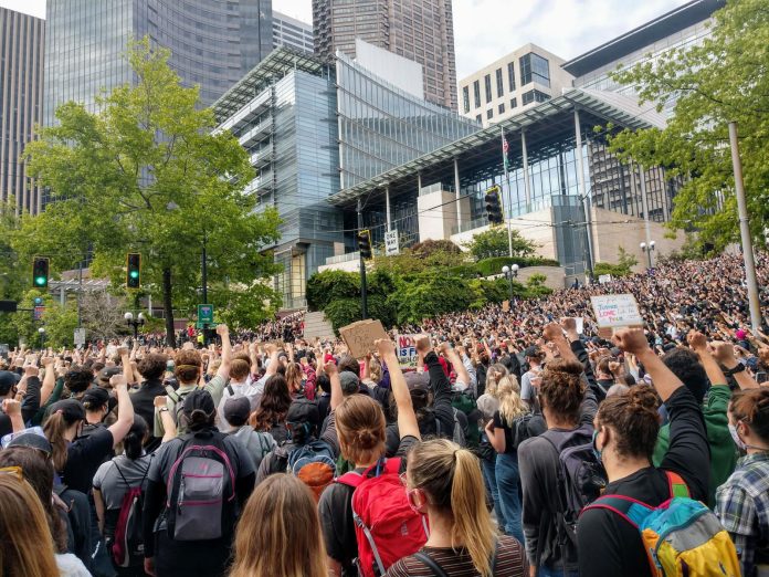 Fist Raised Protesters City Hall Protesters react with fists raised in solidarity as Nikkita Oliver takes the stage at City Hall on Wednesday June 3rd. (Photo by Doug Trumm)