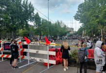 SPD Hopes to Reclaim East Precinct from CHAZ, but Protesters Say Finders Keepers People look on a cordoned off Pine Street just before protesters add "Black Lives Matter Way" in big block letters. (Photo by author)