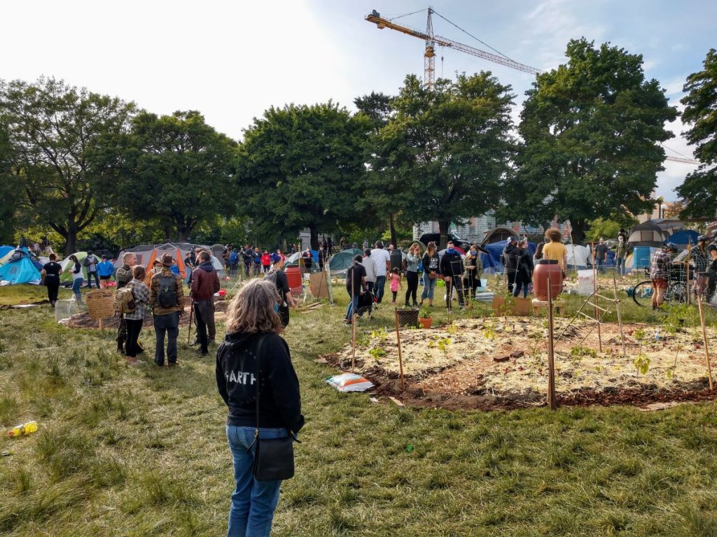 People gather and admire the garden that Marcus Hendersen spearheaded at Cal Anderson Park. (Photo by Doug Trumm)