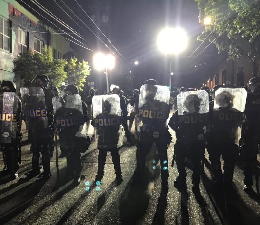 Streetcar and 101 ‘Ghost’ Positions at SPD Survive Budget Deliberations A wall of police with riot shields outside East Precinct.