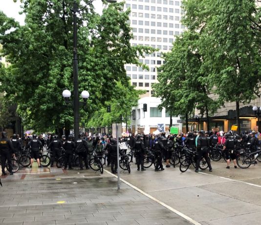Seattle Police Fleecing City with Overtime, Report Shows A large contingent of police barricaded 4th Avenue with their bicycles, blocking a route out of Westlake Park. (Photo by Robert Cruikshank)