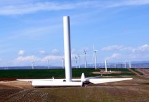 Renewable Energy Can Power America’s Grid and Its Economic Recovery Wind turbines with one half-constructed turbine in the foreground.