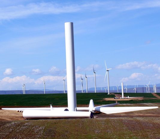Renewable Energy Can Power America’s Grid and Its Economic Recovery Wind turbines with one half-constructed turbine in the foreground.