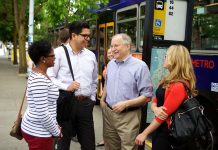 2020 Endorsement Questionnaire: Frank Chopp, LD43-2 Frank Chopp smiles next to three transit riders at a bus stop.