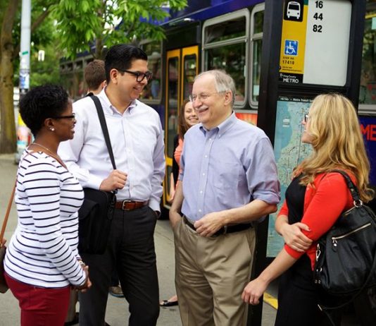 2020 Endorsement Questionnaire: Frank Chopp, LD43-2 Frank Chopp smiles next to three transit riders at a bus stop.