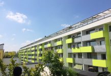 Seattle Must Require Public Buildings Meet Passivhaus Standards to Lead on Climate A large lime green seven-story apartment building in Vienna. (Photo by Mike Eliason)