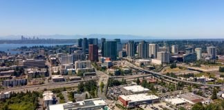Downtown Bellevue viewed from the east with I-405 chasm setting off Wilburton. Seattle skyline and Lake Washington in the background. (