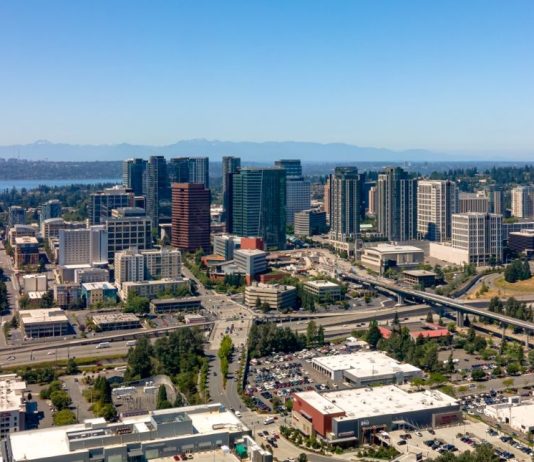 Despite Its Bluster, Bellevue Is Ill-Prepared for Amazon Boom Downtown Bellevue viewed from the east with I-405 chasm setting off Wilburton. Seattle skyline and Lake Washington in the background. (
